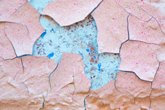 A close up of a piece of paper with paint peeling off of it
