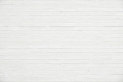 a woman standing in front of a white brick wall