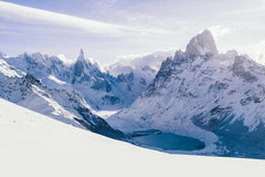 Snowy mountain range with a frozen lake below